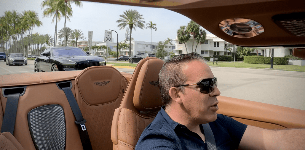 Man driving a convertible car on a sunny day.